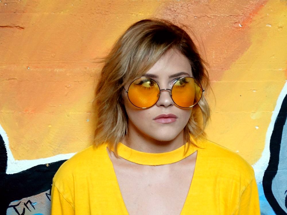 College student fashion at WVU: Shelby wears a yellow cutout tee shirt and round yellow sunglasses