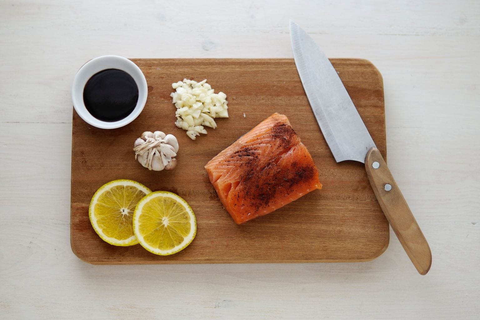 salmon on chopping board with lemon and garlic