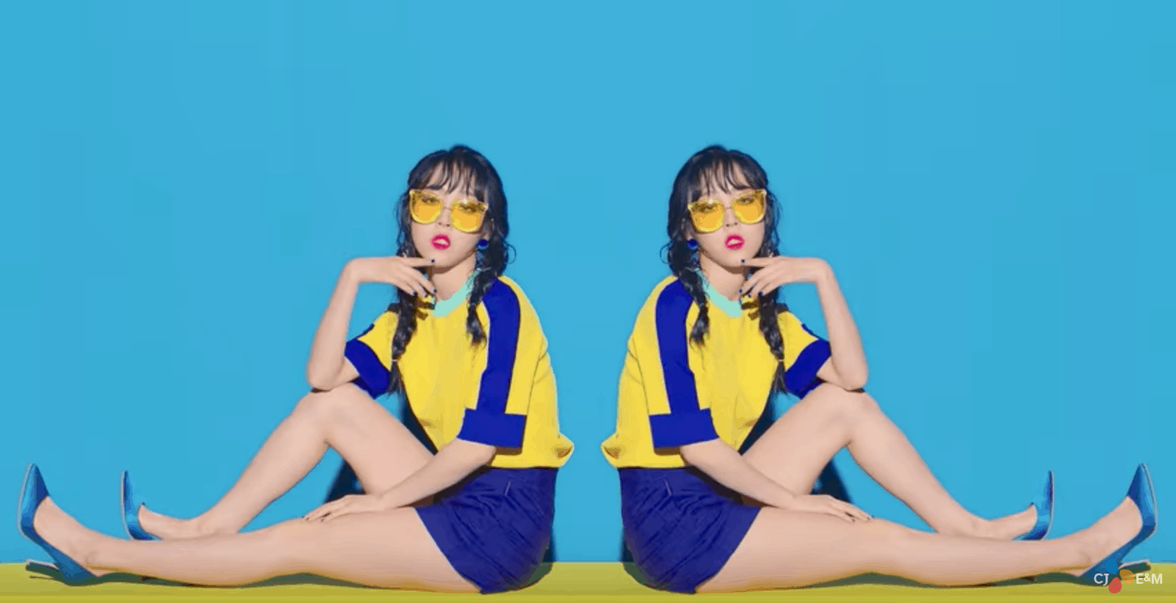 Mamamoo "Yes I Am" fashion: band member wears outfit of blue shorts, blue high heels, yellow and blue tee shirt, yellow sunglasses and braids