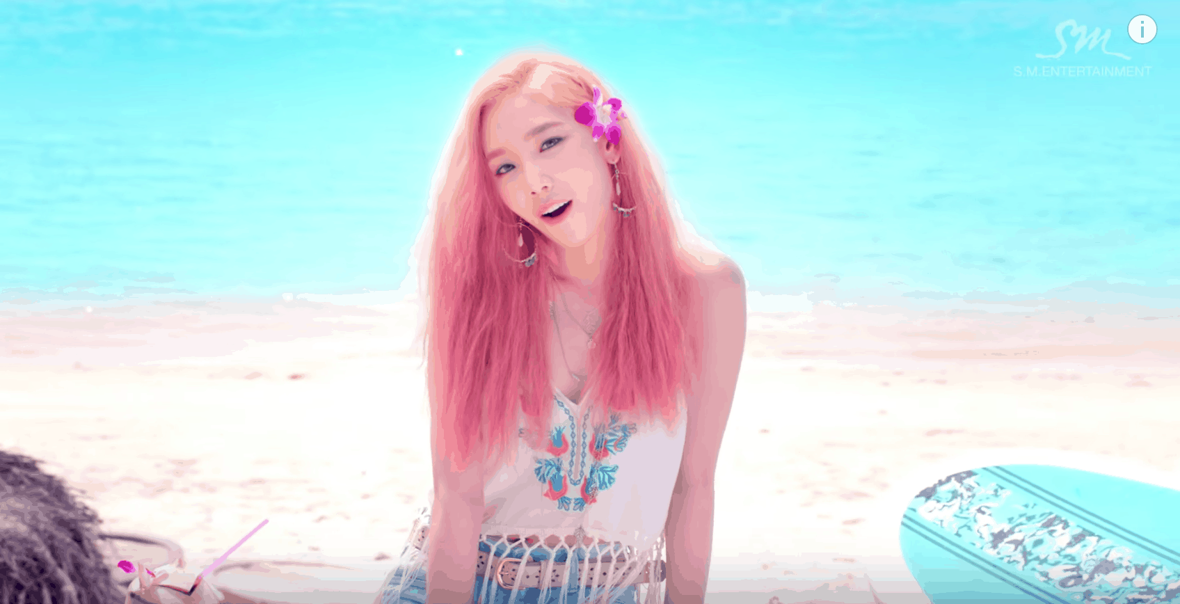 Girls Generation Party Music Video fashion - Band member with pink hair wears a fringe crop top in pink, hoop earrings, denim shorts, a belt, and a flower in her hair