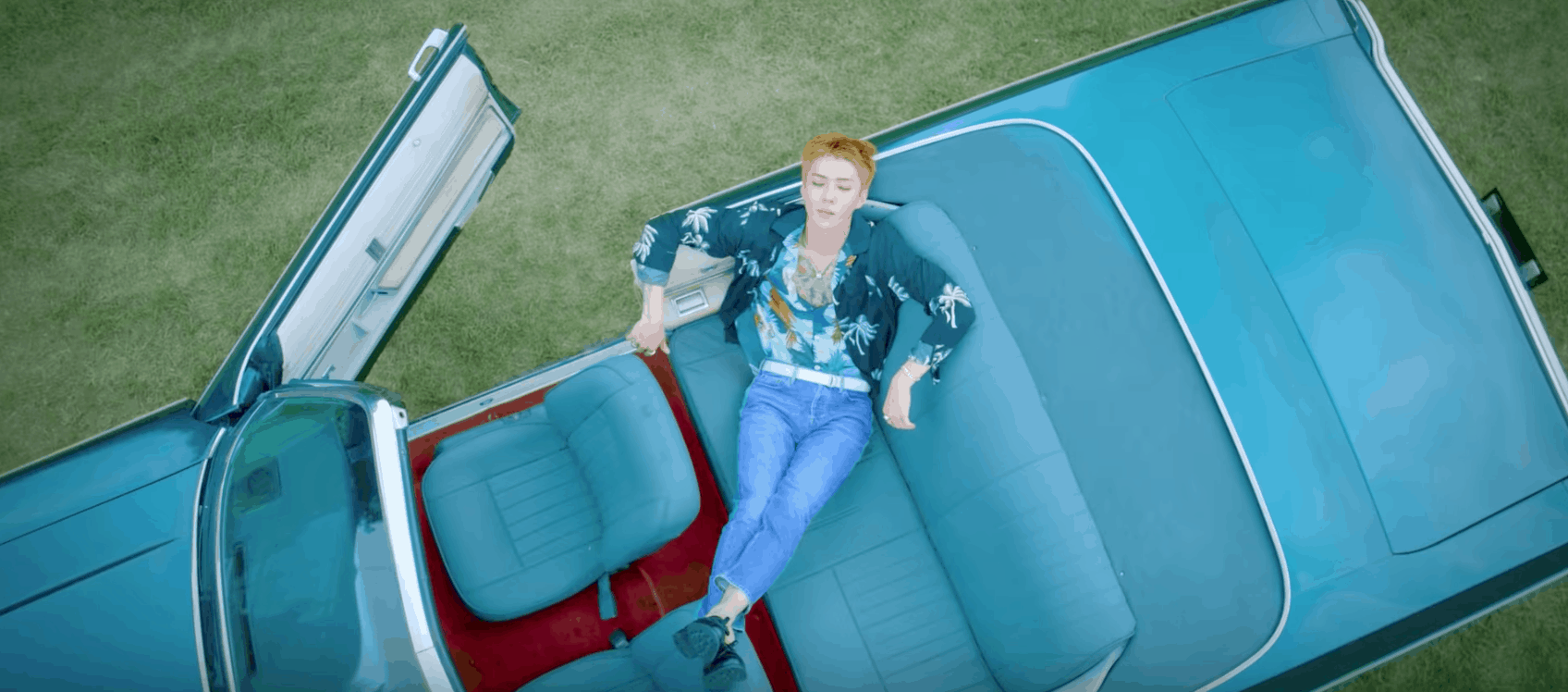 EXO Ko Ko Bop Video - Redheaded member sitting in a blue convertible car