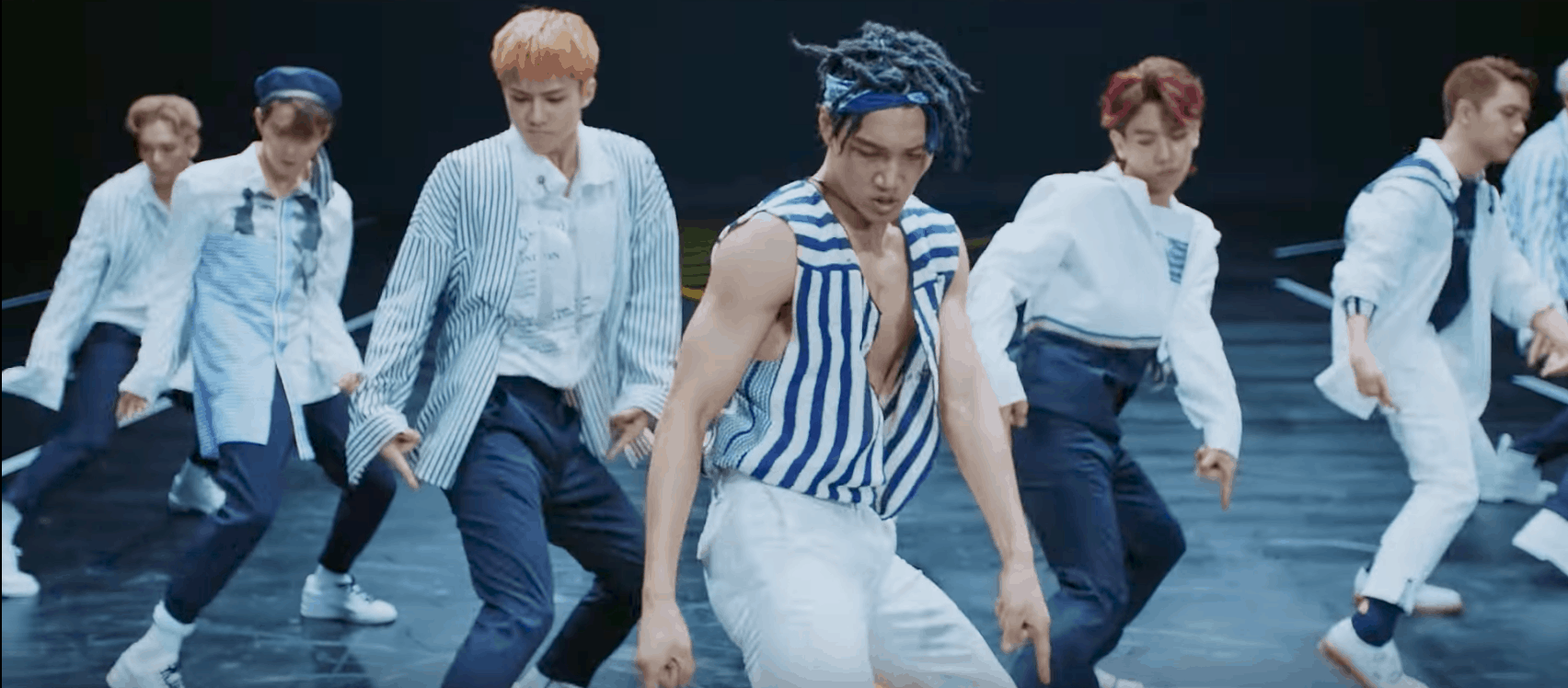 EXO Ko Ko Bop Video - the boys doing a dance routine wearing striped shirts and navy pants