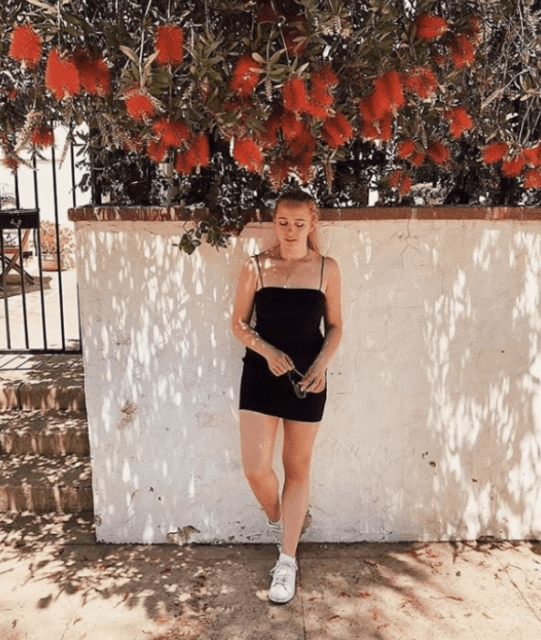 Girl wearing black dress and sneakers