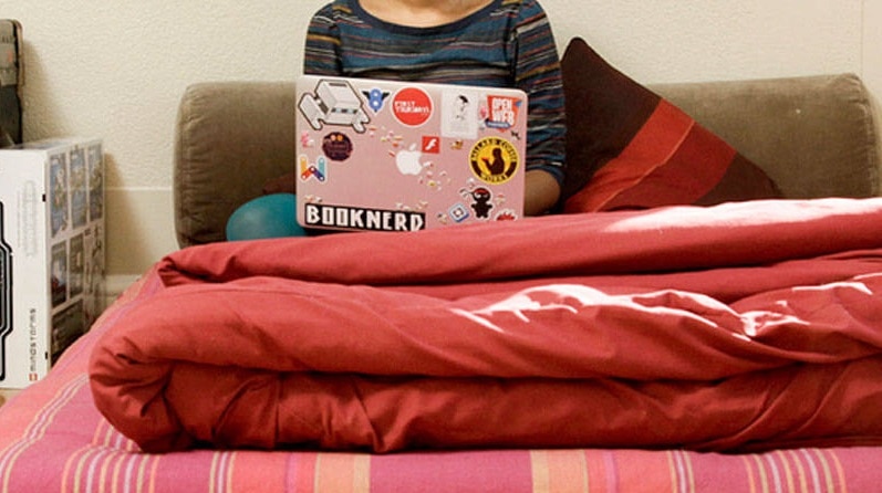 person on computer in bed
