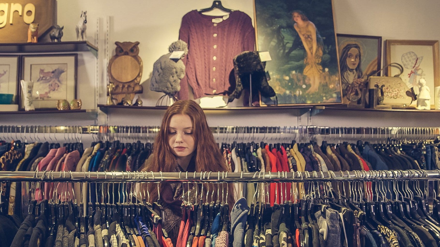 Girl looking through racks of clothing.