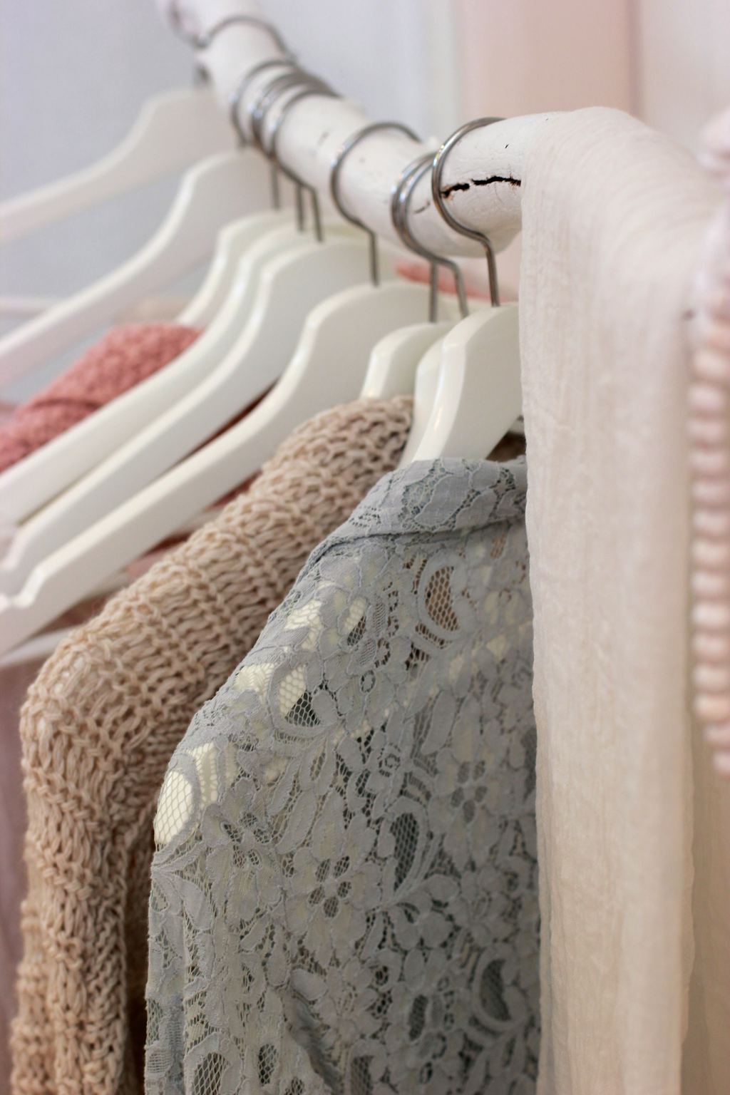 Photo of several pastel-colored clothing items on hangers