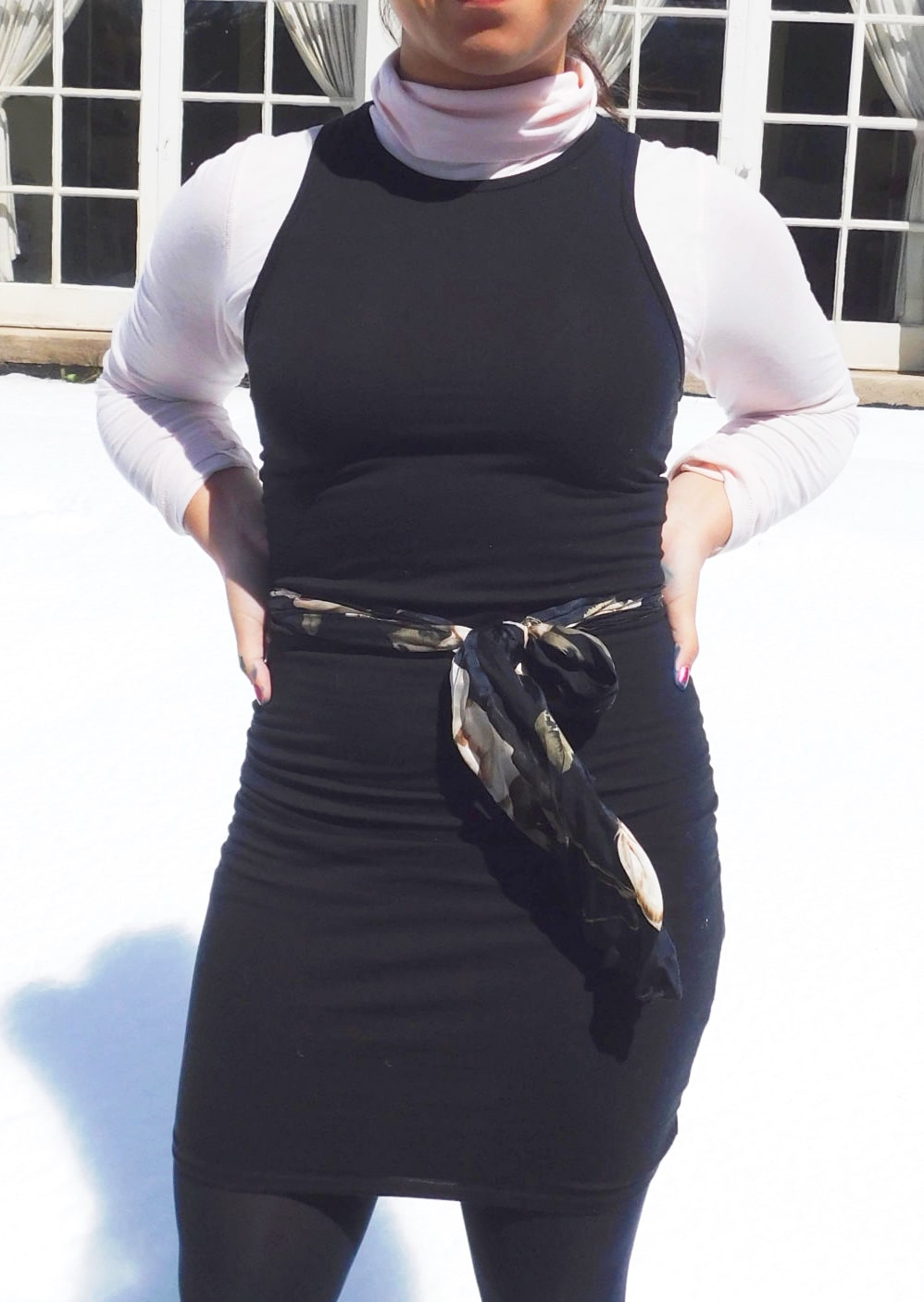 This high-neck black bodycon tank dress is worn with opaque black tights, a pastel pink hand-me-down turtleneck, and a thrifted silky scarf worn as a belt.