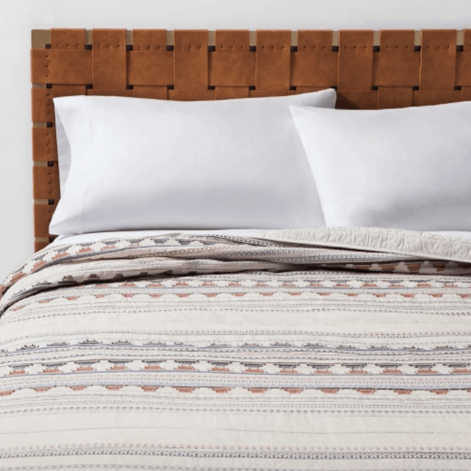 This simple cream jacquard Target quilt has a coral and blue striped pattern.