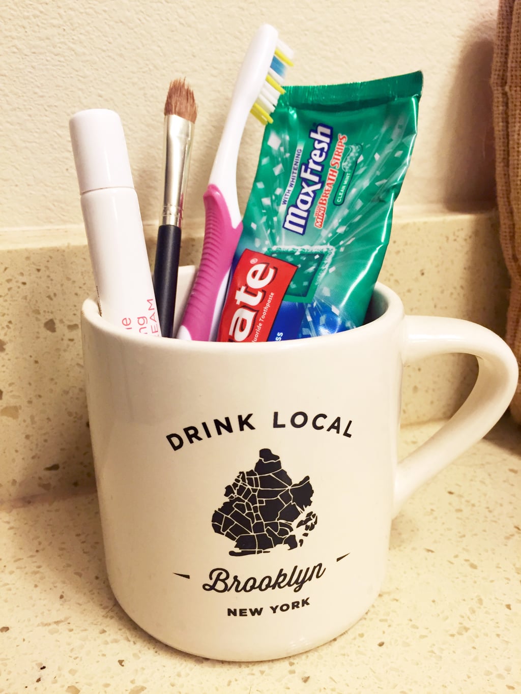 Brooklyn mug used to hold toothbrush and toothpaste in the bathroom