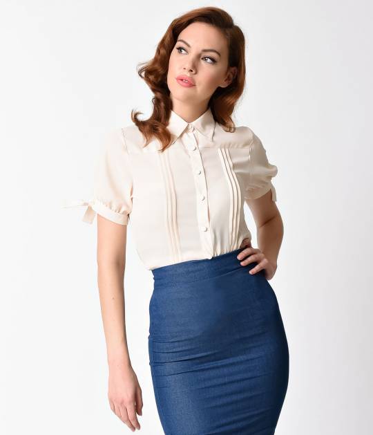 Woman wearing a vintage cream blouse from Unique Vintage and a blue pencil skirt
