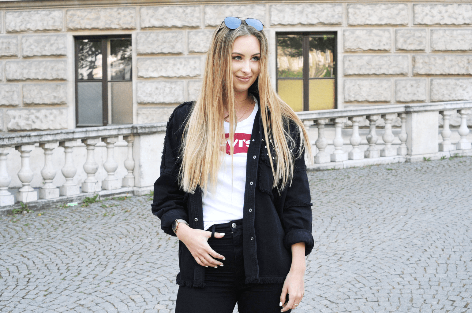 Fashion on campus at the University of Austria - student Anika wears skinny black jeans, an oversized black button down shirt, a white Levi's tee shirt, and aviator sunglasses