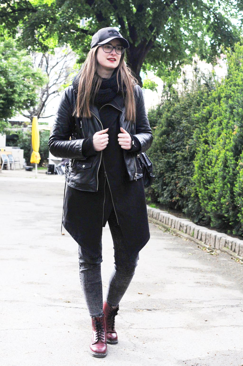 Fashion at the University of Vienna: Student Iris wears gray jeans, burgundy doc martens, a black leather jacket, red lipstick, a baseball cap and glasses