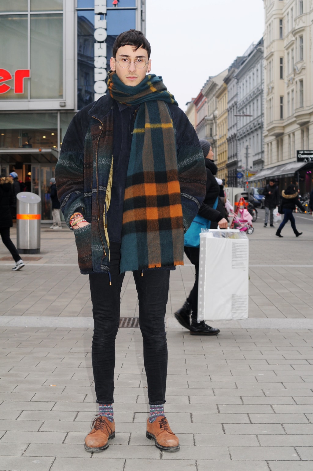 Mens fashion at the University of Vienna in Austria: Plaid coat, plaid scarf, black skinny jeans, oxfords, patterned socks