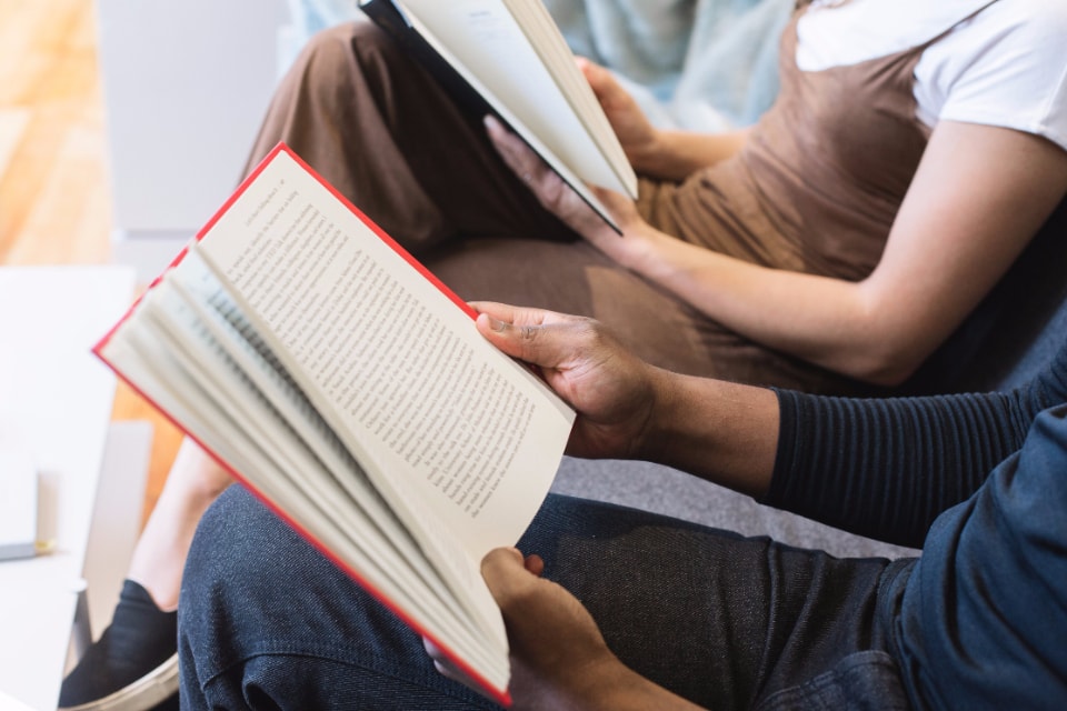 Woman and man sitting on couch reading