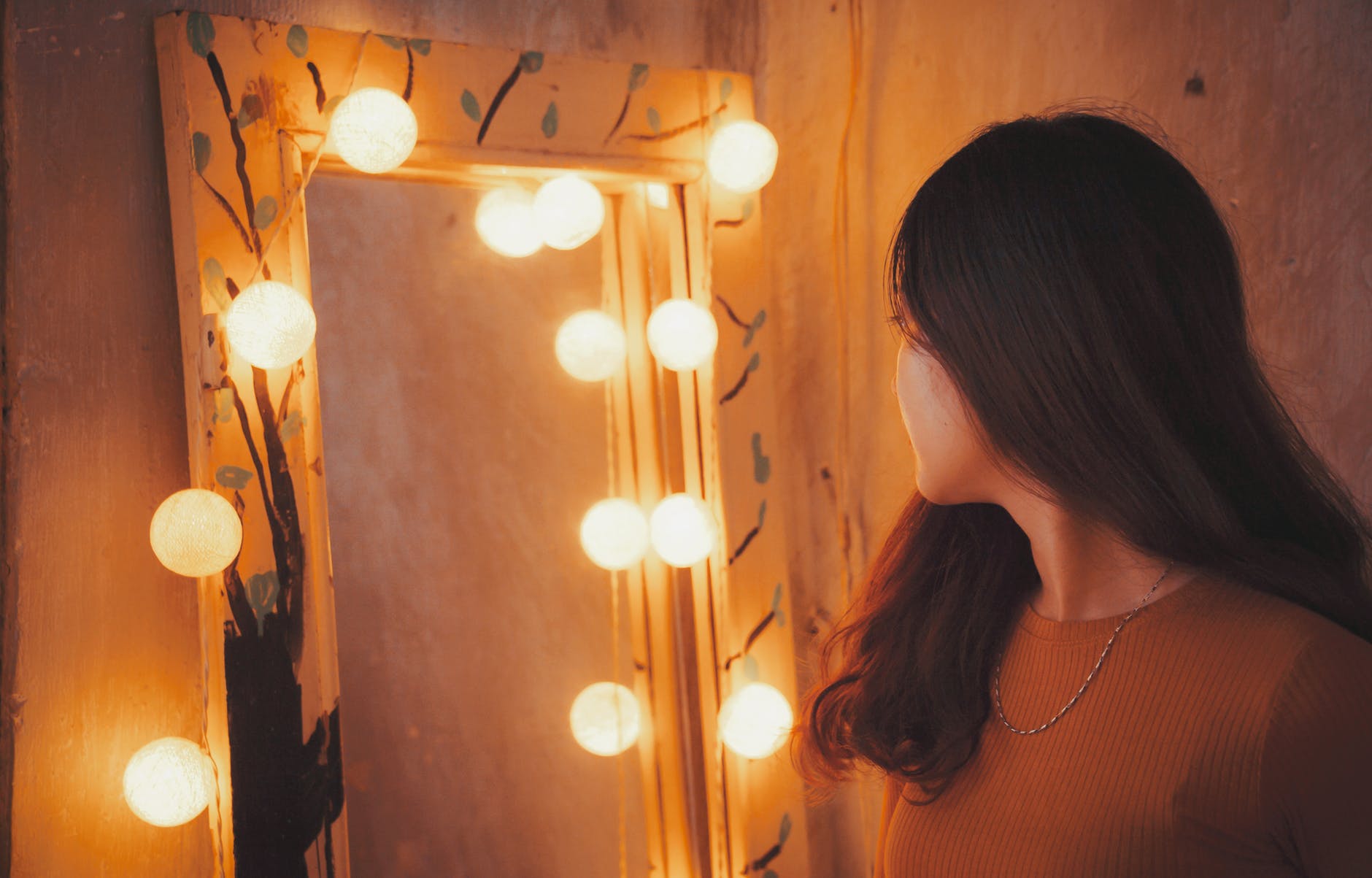 Woman looking at herself in a lighted mirror