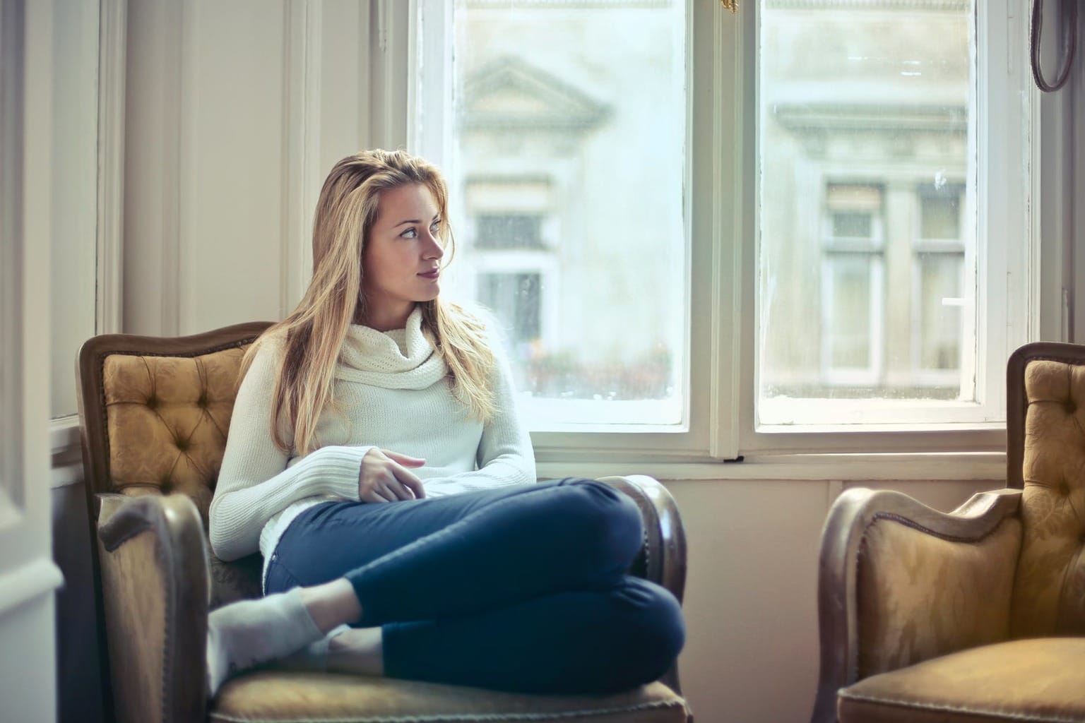 Woman sitting in a chair looking out of the window