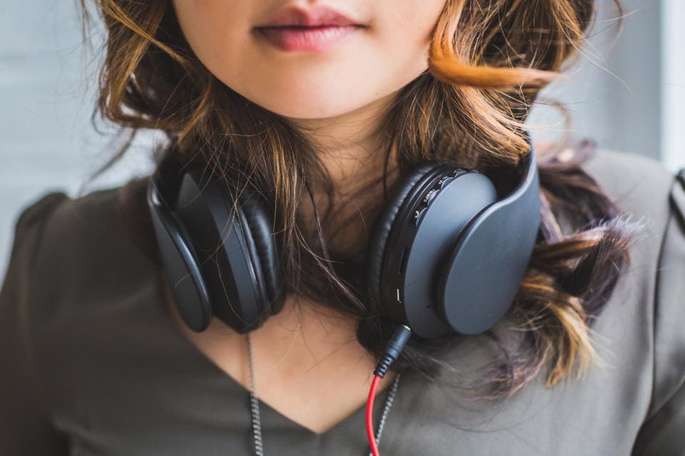 Woman with black headphones around neck