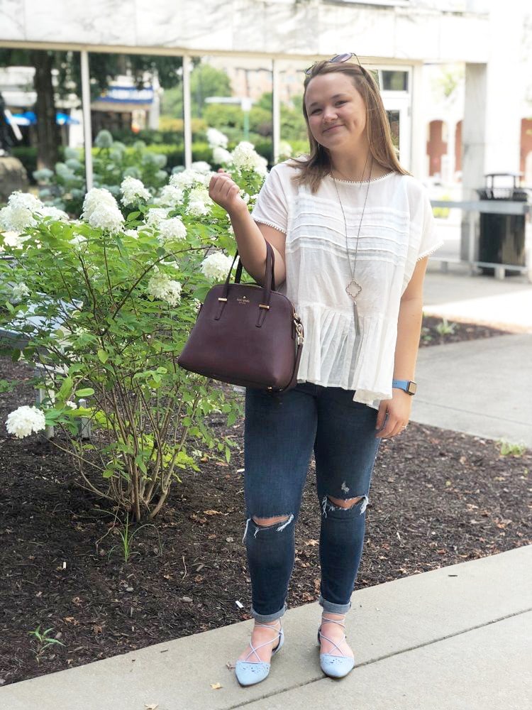 WVU fashion - Sarah wears a ruffle top, Kate Spade bag, Kendra Scott necklace, ripped jeans, and baby blue flats