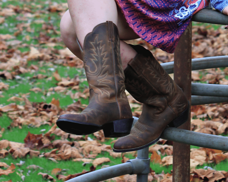 This GVSU student wears distressed dark brown cowboy boots with light-brown stitching.