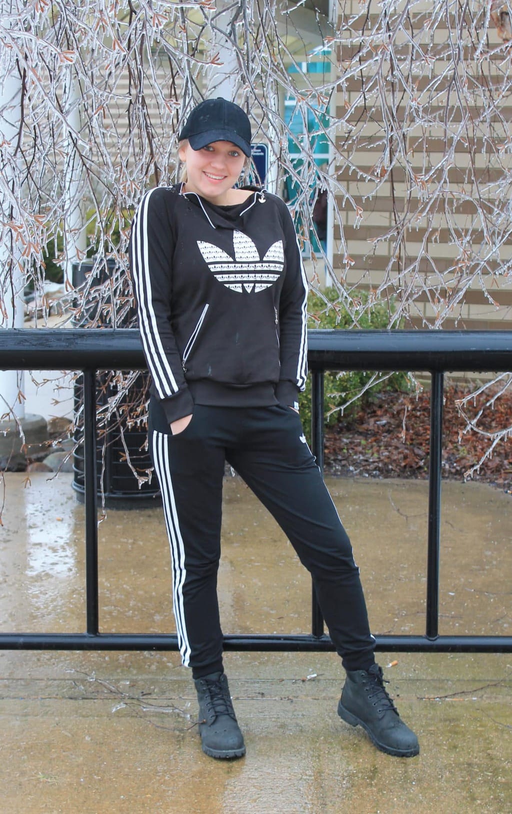 University student wears a black and white Adidas tracksuit with a plain black baseball cap and Timberland boots.