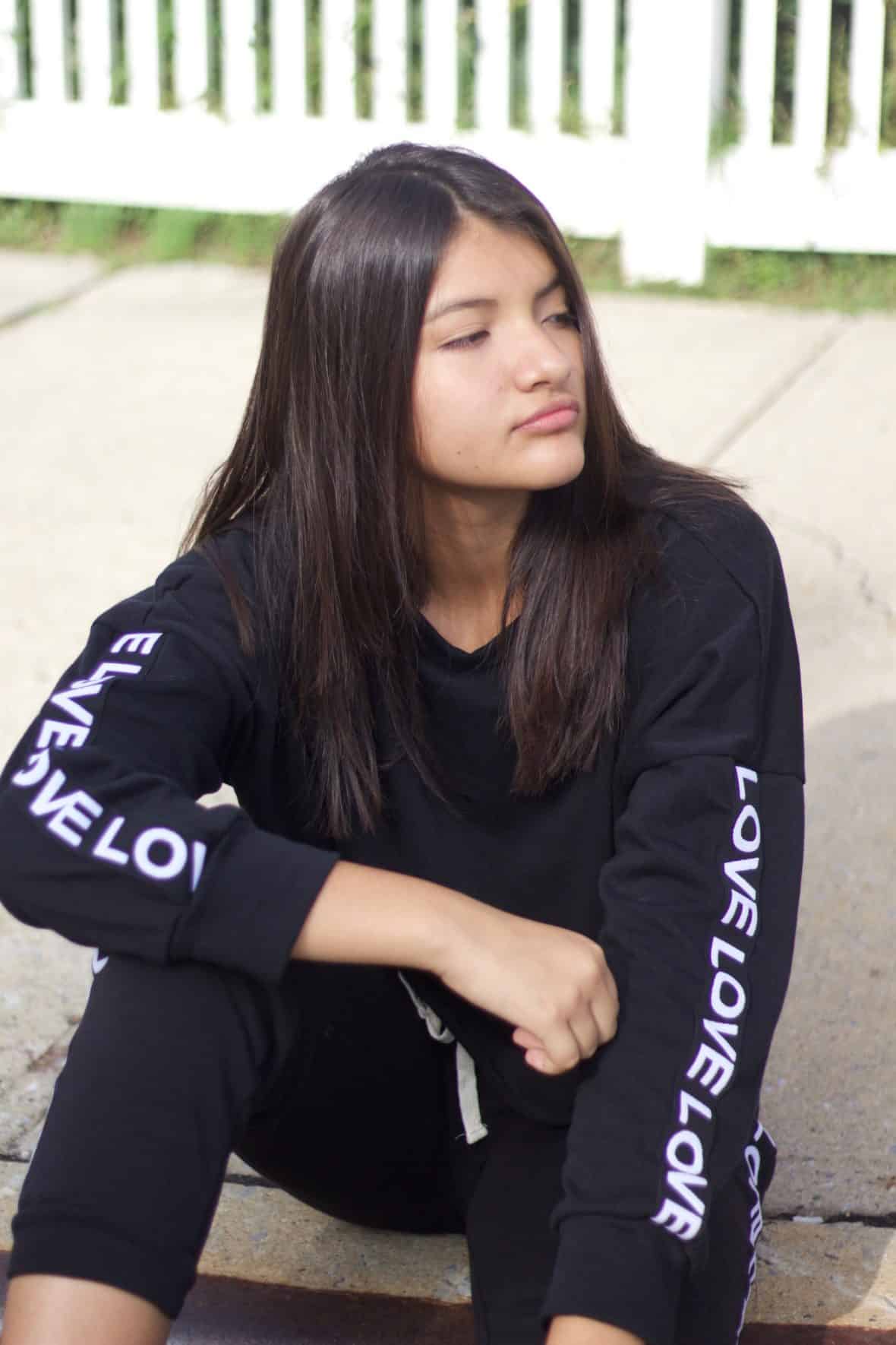 Nathaly wears a black and white tracksuit.