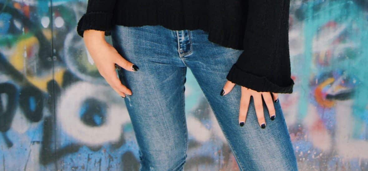 Renee wears light-wash faded jeans.