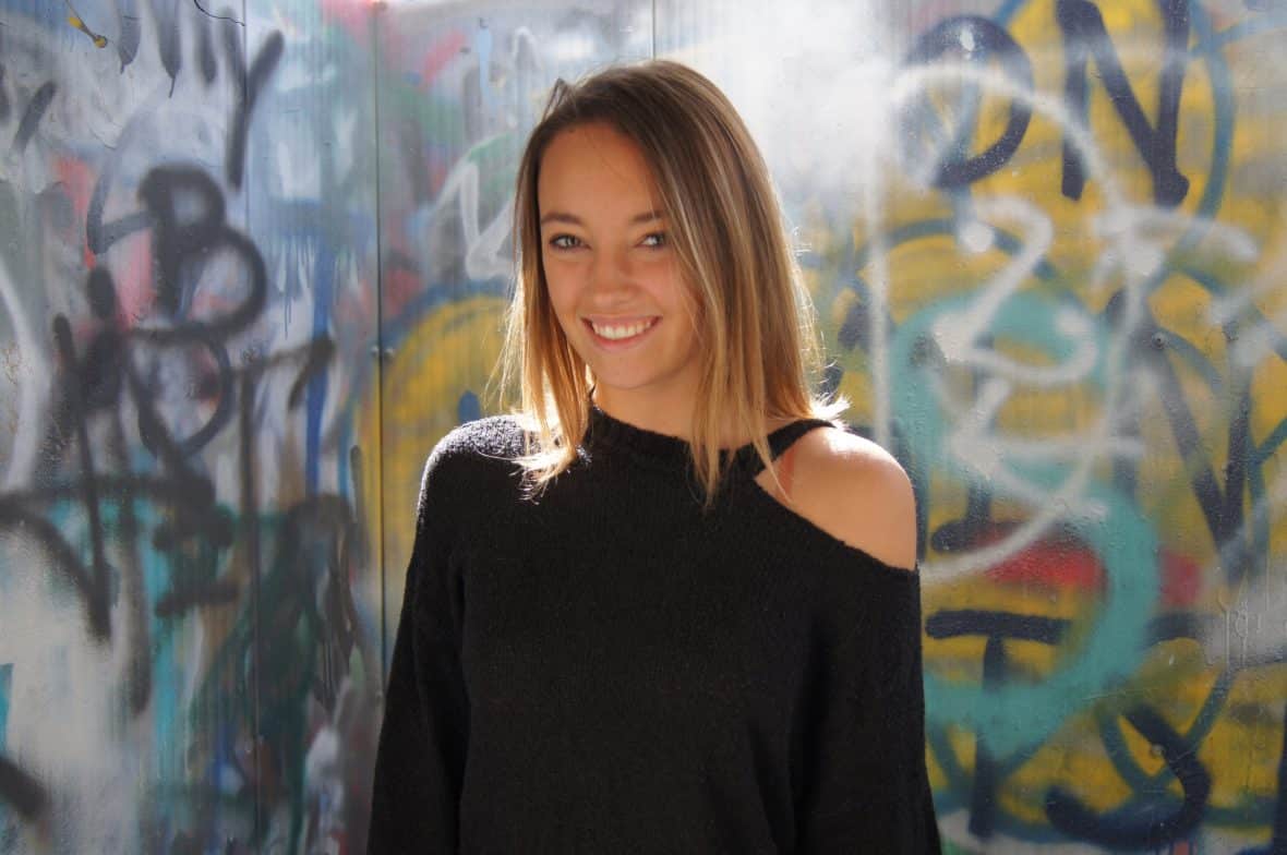 Renee, a student at Virginia Tech, wears a fuzzy black sweater with an asymmetrical shoulder cut-out.