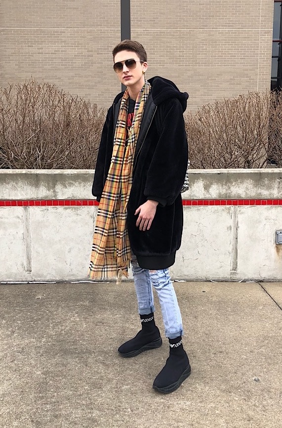 Fashion at WVU - student Kevin wears black sneakers, distressed jeans, a Burberry scarf, sunglasses, and an oversized black coat