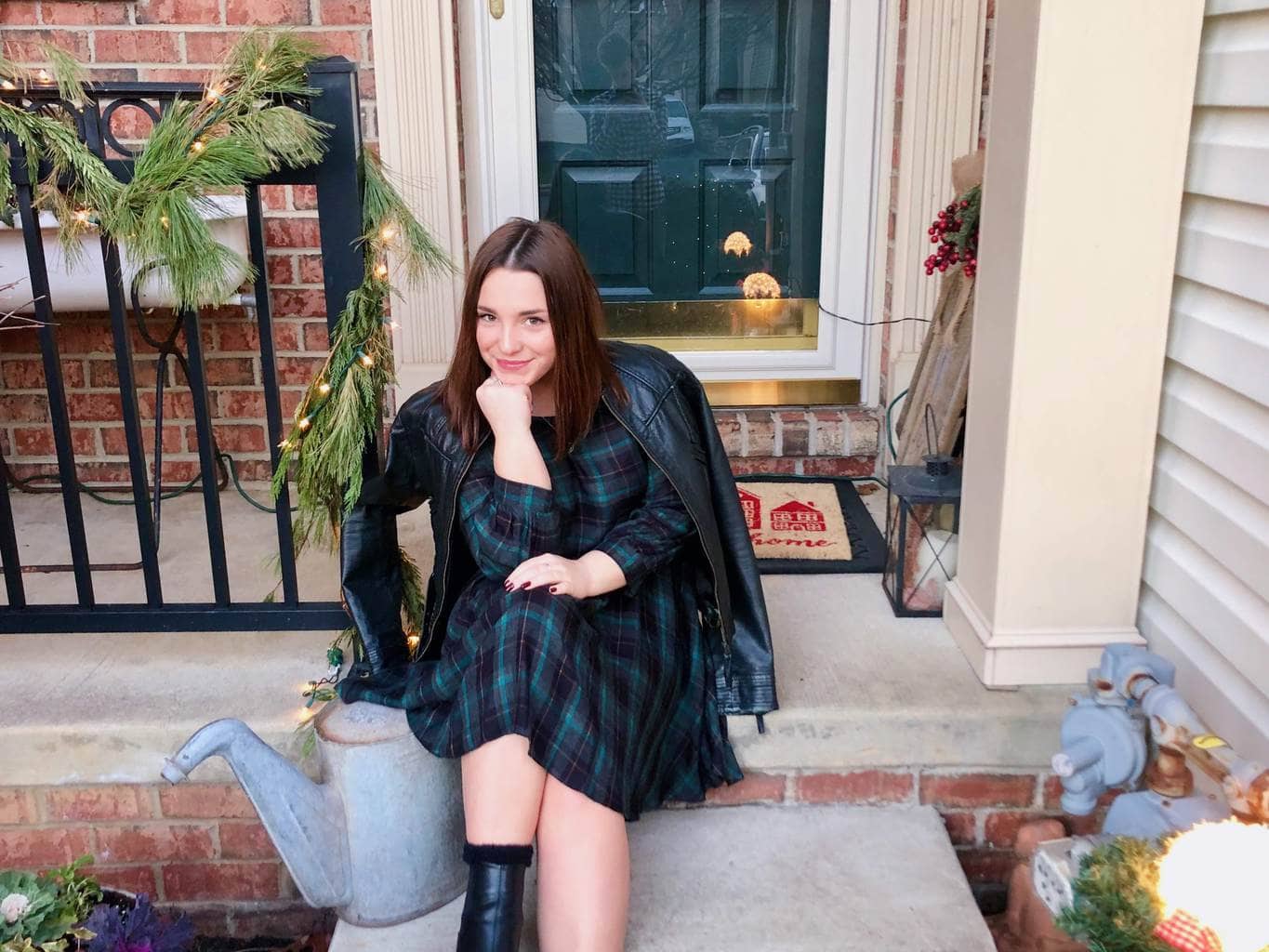 Girl sitting on steps in a plaid dress