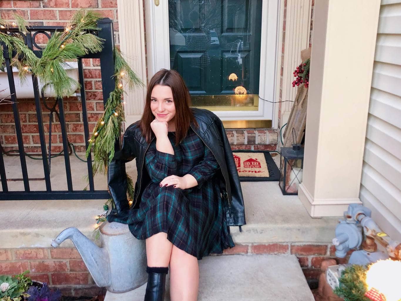 Girl sitting on steps in a plaid dress