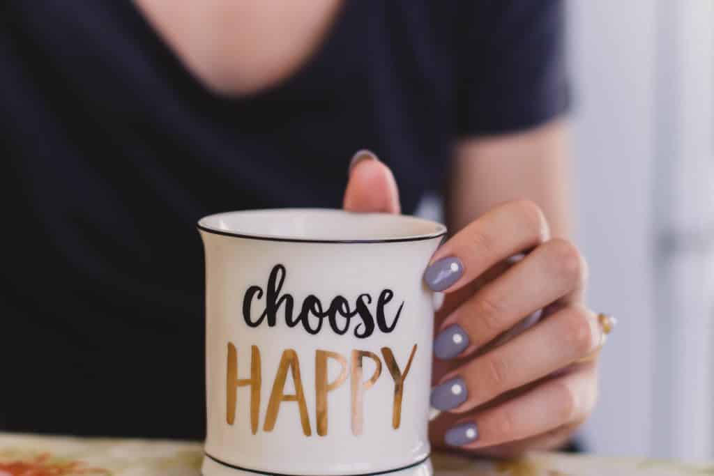 Girl holding a choose happy mug