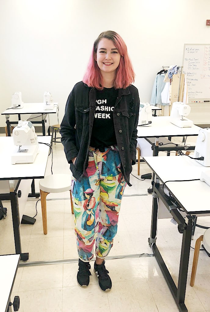 WVU campus style: Funky outfit on Sonora who wears printed pants, fashion week tee, and denim jacket with pink hair