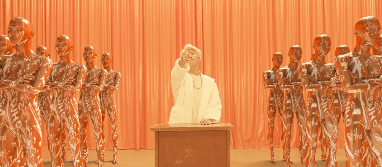 BTS persona video still - RM surrounded by robots in all white