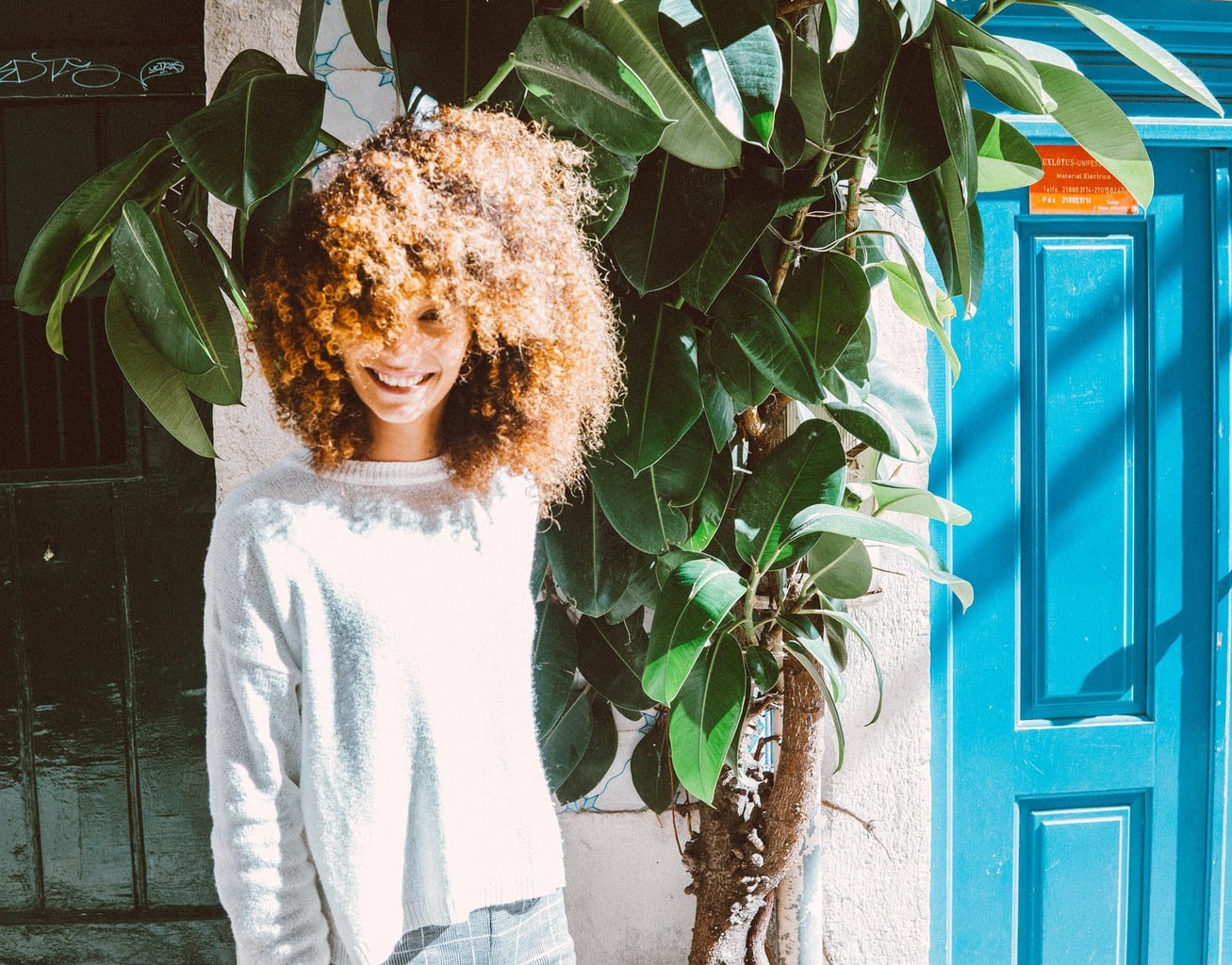 curly hair girl next to trees