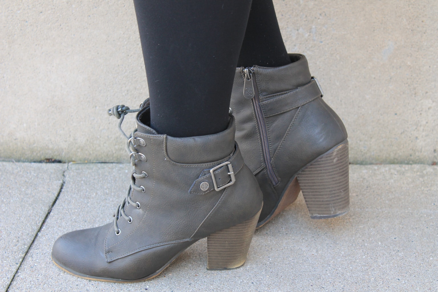 Katie sports grey chunky-heeled lace up booties with straps and buckles.