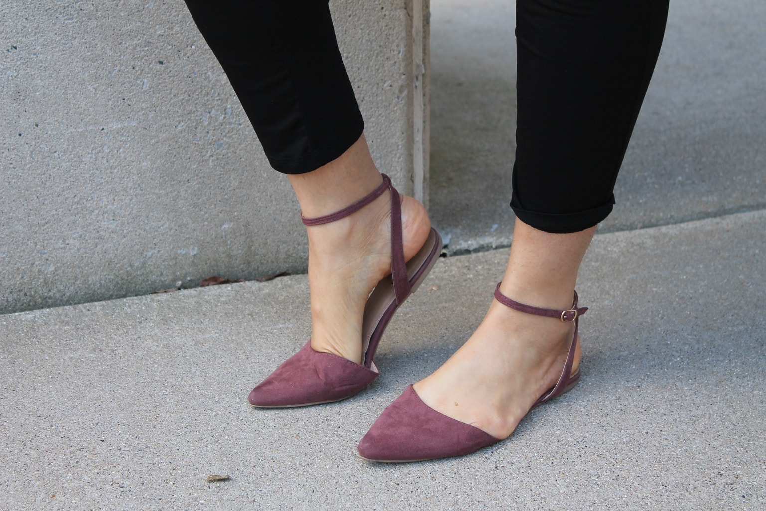 These pointed-toe flats are mauve and have an ankle strap.