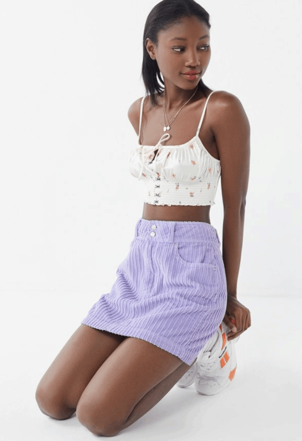 model in cropped tank top and lilac corduroy mini skirt
