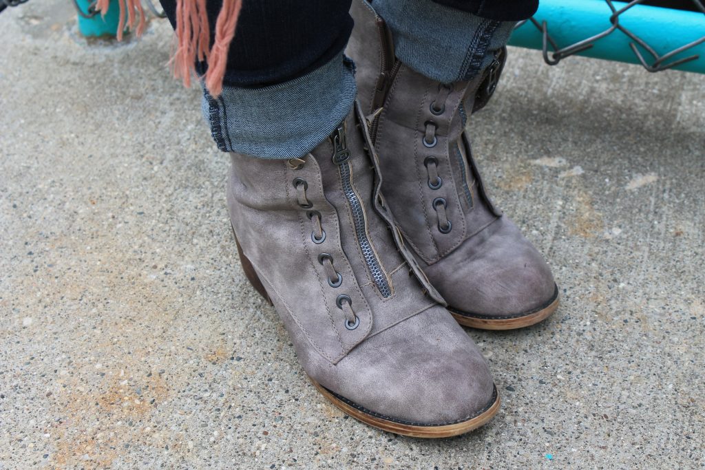 Brandi wears grey heeled booties with zippers.