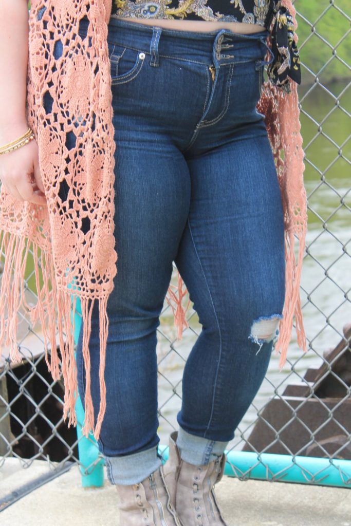 Brandi wears high-waisted medium-wash denim jeans cuffed.