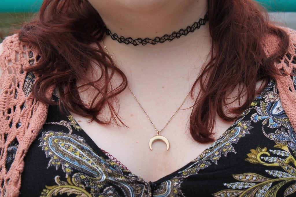 This student wears a black stretchy choker necklace and a simple gold moon pendant.