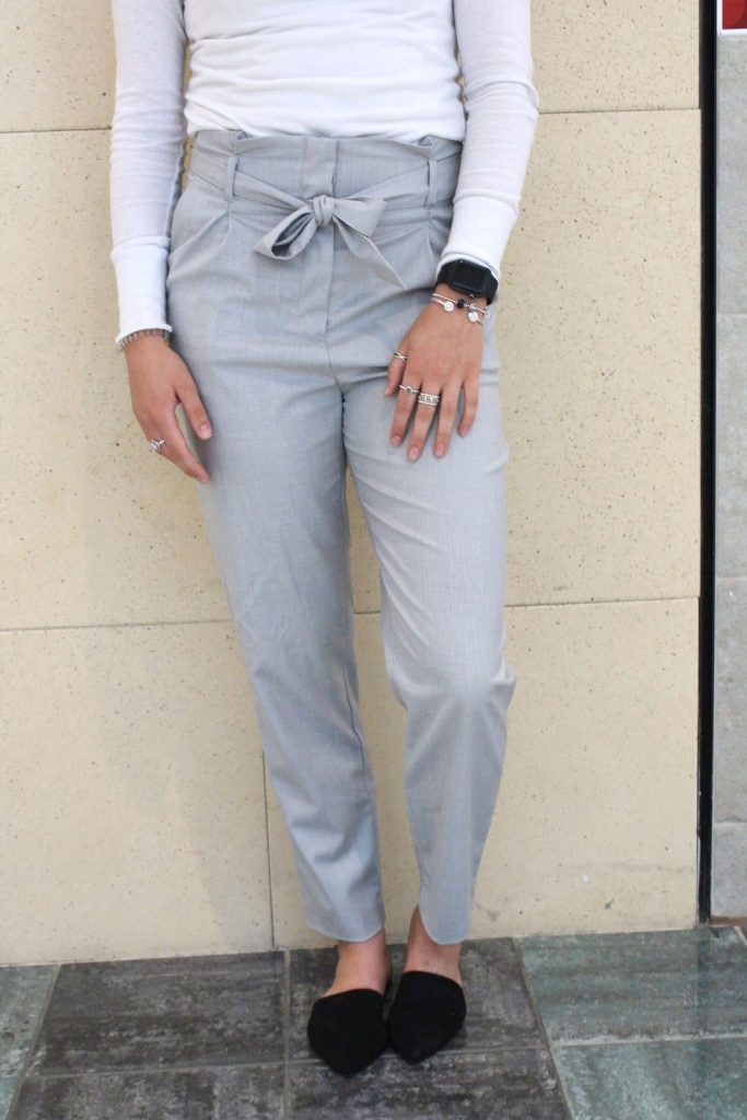 This Grand Valley State University student wears tapered grey trousers that have a tied fabric belt.