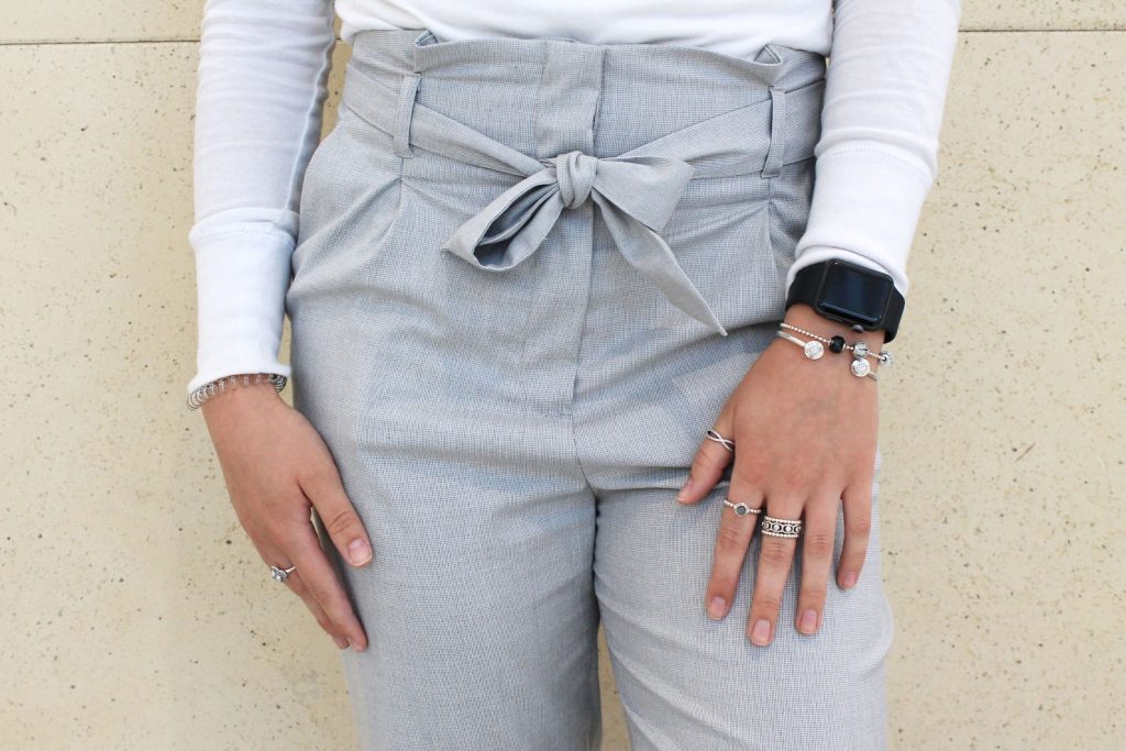 Darby wears stacked silver bracelets and rings.