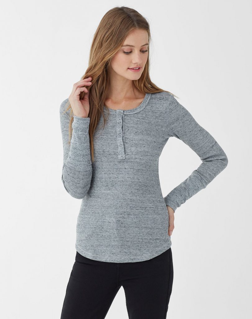 Woman wearing long-sleeved heather gray henley top with black pants.