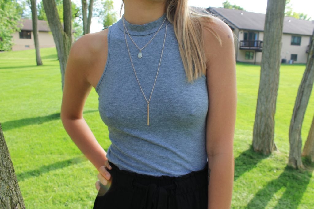 This Grand Valley State University student wears a grey high neck tee with layered gold necklaces.