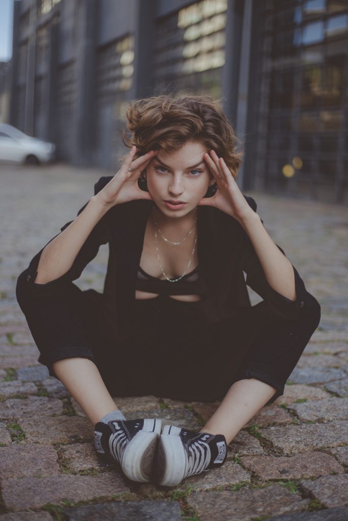 Young woman wearing black holding her head