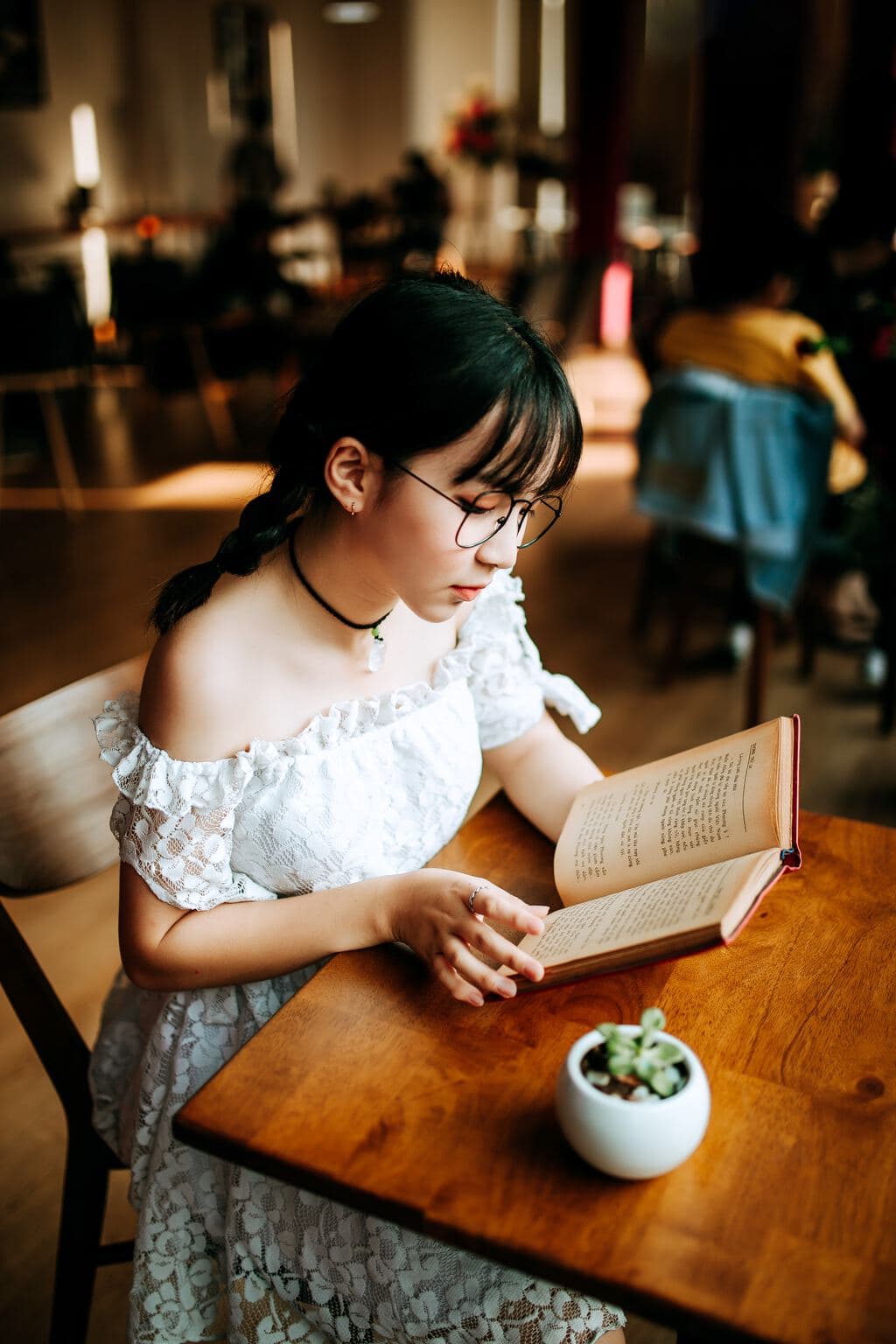 Woman sitting at a table, reading a book