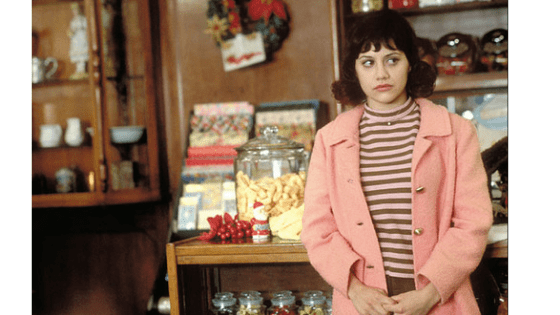 Daisy from Girl Interrupted in a pink jacket and striped top