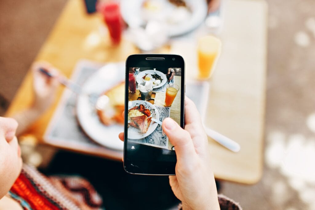 Person taking a picture of a brunch meal.