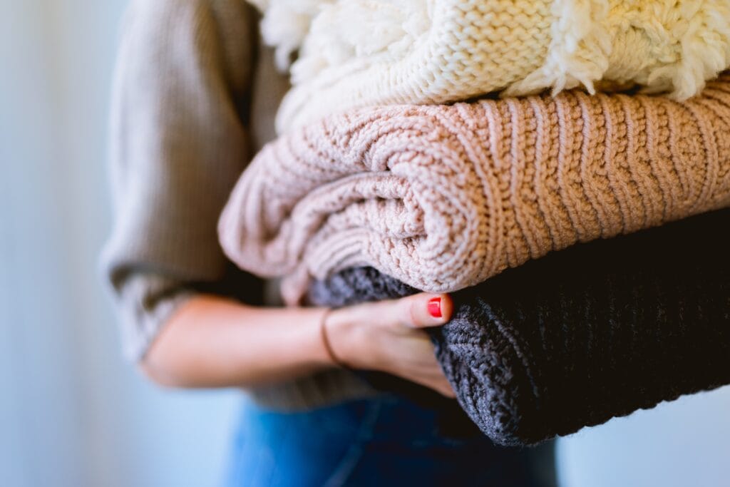 white pink and black stack of sweaters