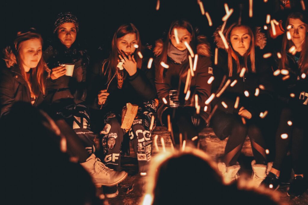 group of people sitting around a fire